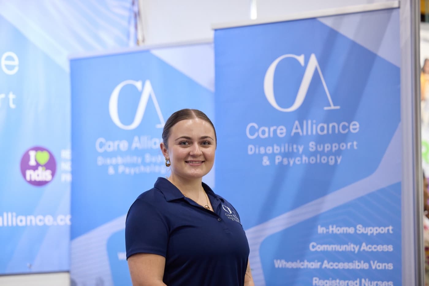 A Care Alliance team member in branded uniform at the Care Alliance stand