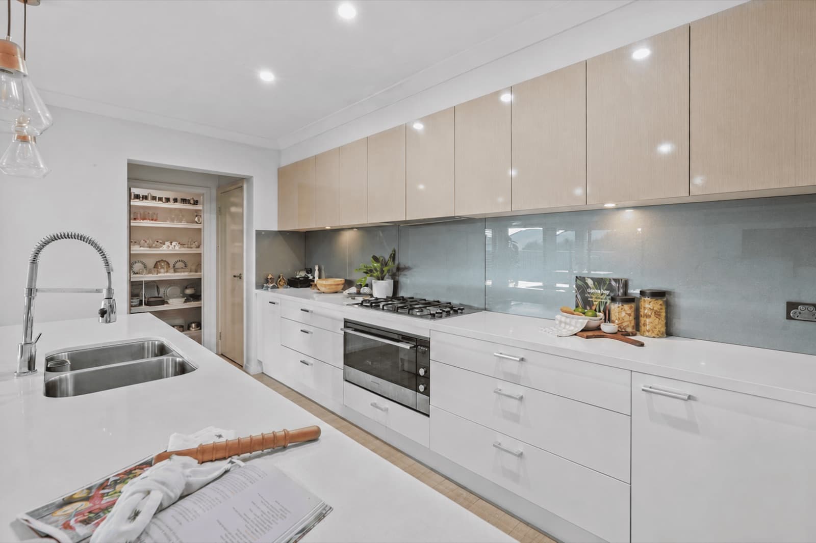 Modern kitchen with stone benchtops, gas cooktop and walk-in pantry