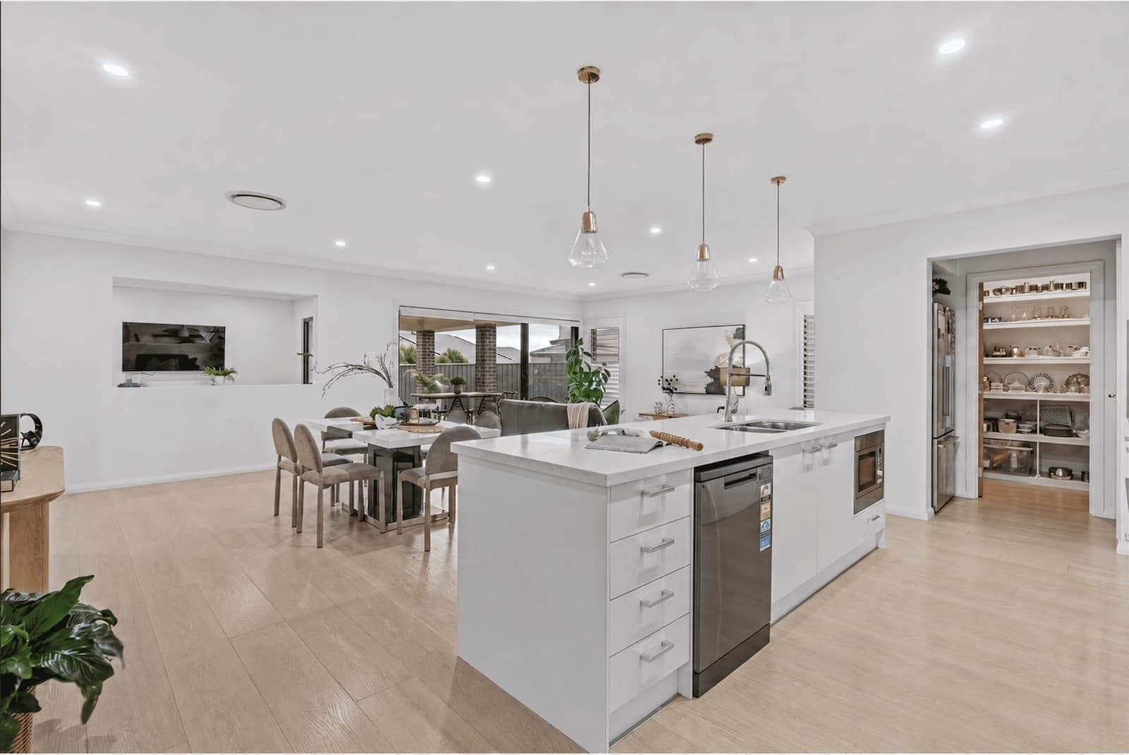 Open-plan living and dining area flowing to the covered alfresco