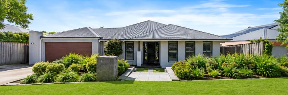 Front of the Raworth SIL home — single-level house with established native gardens and paved entry path