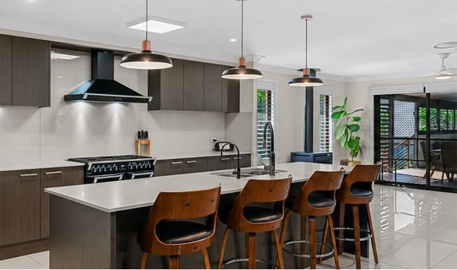 Kitchen island with breakfast stools, freestanding oven and pendant lighting