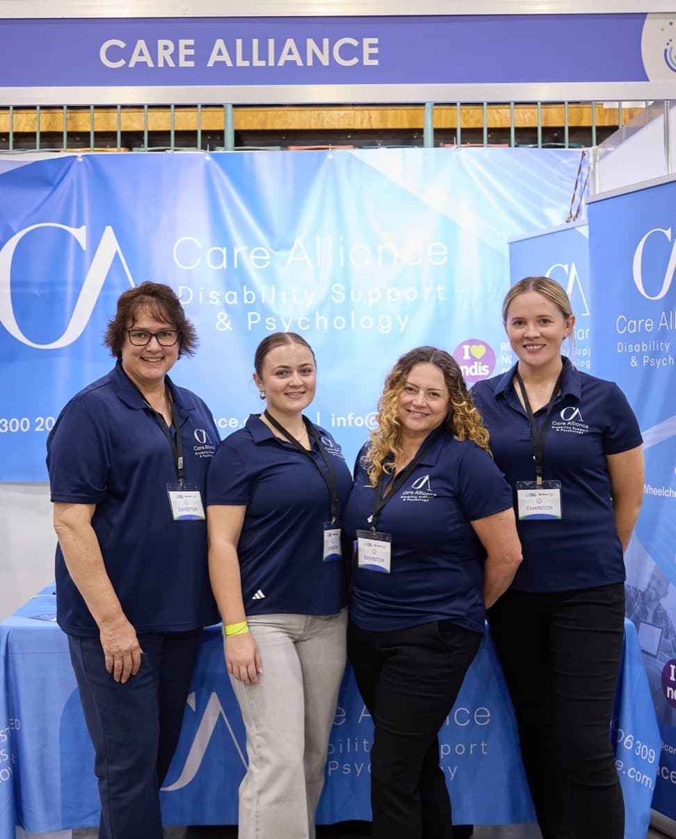Four Care Alliance team members in uniform at the Care Alliance stand at the Hunter Disability Expo