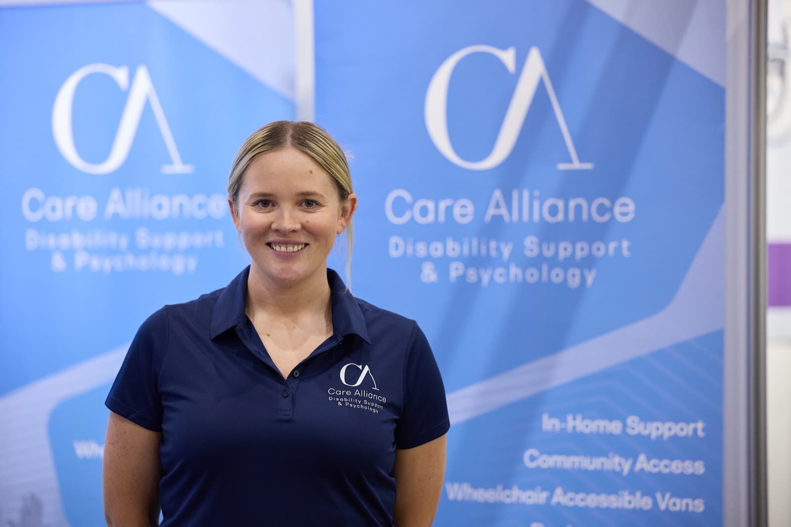 Care Alliance team member smiling at the company stand