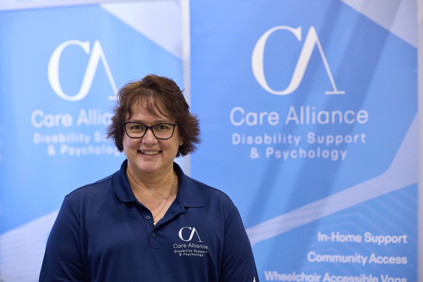 A Care Alliance team member in uniform at the Hunter Disability Expo stand